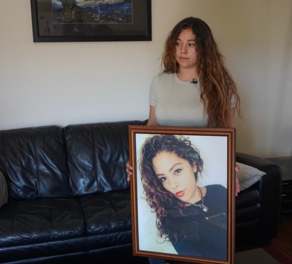 Clarissa Anderson holding a picture of her twin sister Chloe, who died by suicide. The family claims their private insurer did not make available adequate mental health services.