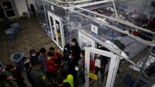 Minors talk to an agent outside a pod at the Department of Homeland Security holding facility run by the Customs and Border Patrol (CBP) on March 30, 2021 in Donna, Texas.