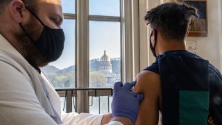 Antonio Sneed, 19, of Morgantown, West Virginia receives the vaccine while overlooking the West Virginia Capitol Building in Riggleman Hall. The Kanawha-Charleston Health Department led a vaccination effort on the campus of the University of Charleston. 1,800 doses of the Johnson & Johnson Janssen Covid-19 vaccine were on hand to be given out to all persons aged 16 years and older.