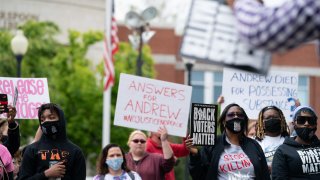 Demonstrators hold signs during a protest march in Elizabeth City, North Carolina