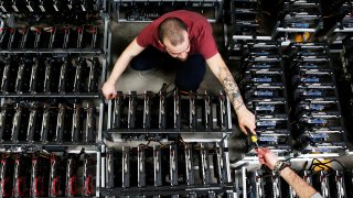 Employees work on bitcoin mining computers at Bitminer Factory in Florence, Italy.