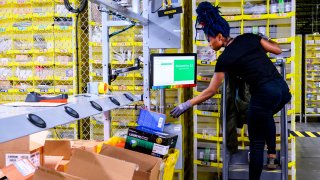 A woman works at a distrubiton station at the 855,000-square-foot Amazon fulfillment center in Staten Island, New York, on February 5, 2019.