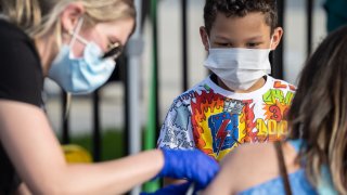 A child watches as a nurse administers a shot of COVID-19 vaccine during a pop-up vaccination event at Lynn Family Stadium on April 26, 2021 in Louisville, Kentucky.