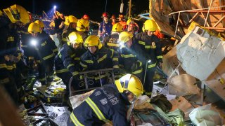 Emergency personnel search through the wreckage of buildings destroyed by a reported tornado in Wuhan in central China's Hubei Province
