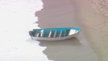 An empty boat, likely related to the human smuggling attempt, washes ashore on Thursday, May 20, 2021.
