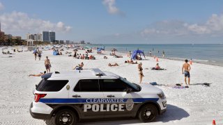 police officers patrol the area after Clearwater Beach officially reopened to the public in Clearwater Beach, Fla.