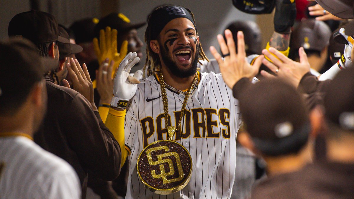 Fernando tatis jr in a padres jersey celebrating with a world