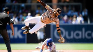 SAN DIEGO, CA โ JUNE 6: Billy McKinney #60 of the New York Mets steals second base as Fernando Tatis Jr. #23 of the San Diego Padres leaps over fielding the throw in the sixth inning at Petco Park on June 6, 2021 in San Diego, California. McKinney safely stole second base. (Photo by Denis Poroy/Getty Images)