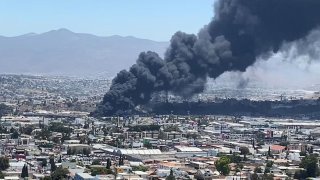 A dark plume of smoke rises above Tijuana on Friday, June 25, 2021.