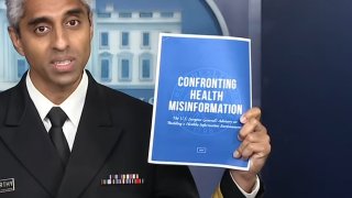 US Surgeon General Vivek Murthy holds up his new advisory on the dangers of health misinformation