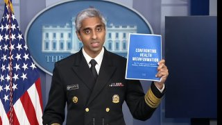 US Surgeon General Vivek Murthy holds up his new advisory on the dangers of health misinformation