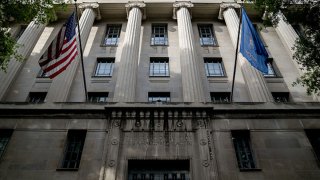 FILE: An American flag flies outside the Department of Justice building in Washington, D.C., U.S., on Monday, June 21, 2021.