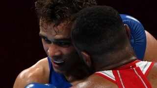 Morocco's Youness Baalla (red) and New Zealand's David Nyika fight during their men's heavy (81-91kg) preliminaries round of 16 boxing match during the Tokyo 2020 Olympic Games at the Kokugikan Arena in Tokyo on July 27, 2021.