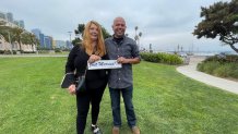 Paulette Lewis and Eduardo Sousa hold a "Just Married" plaque after tying the knot at the Marriage Hut in San Diego. The Waterfront Park spot now offers couples marriage services with no appointments needed every Wednesday.