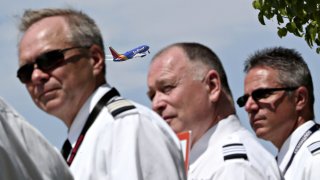 A Southwest Airlines Co. plane takes off as representatives and pilots from the Southwest Airlines Pilots’ Association (SWAPA) demonstrate outside Chicago Midway International Airport (MDW) in Chicago, Illinois, U.S., on Wednesday, May 18, 2016.