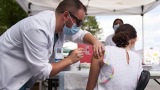 healthcare worker administers a dose of the Pfizer-BioNTech Covid-19 vaccine