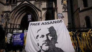 Supporters of WikiLeaks founder Julian Assange hold up a banner as they protest