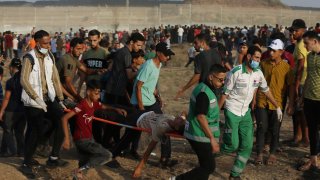Medics evacuate a wounded person from the fence of Gaza Strip border with Israel