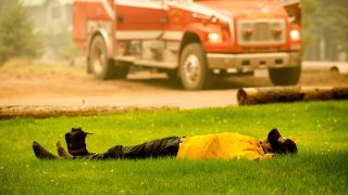 Healdsburg firefighter Justin Potter rests as his crew prepares to battle the Dixie Fire in the Clear Creek community of Lassen County, Calif., on Friday, Aug. 6, 2021.