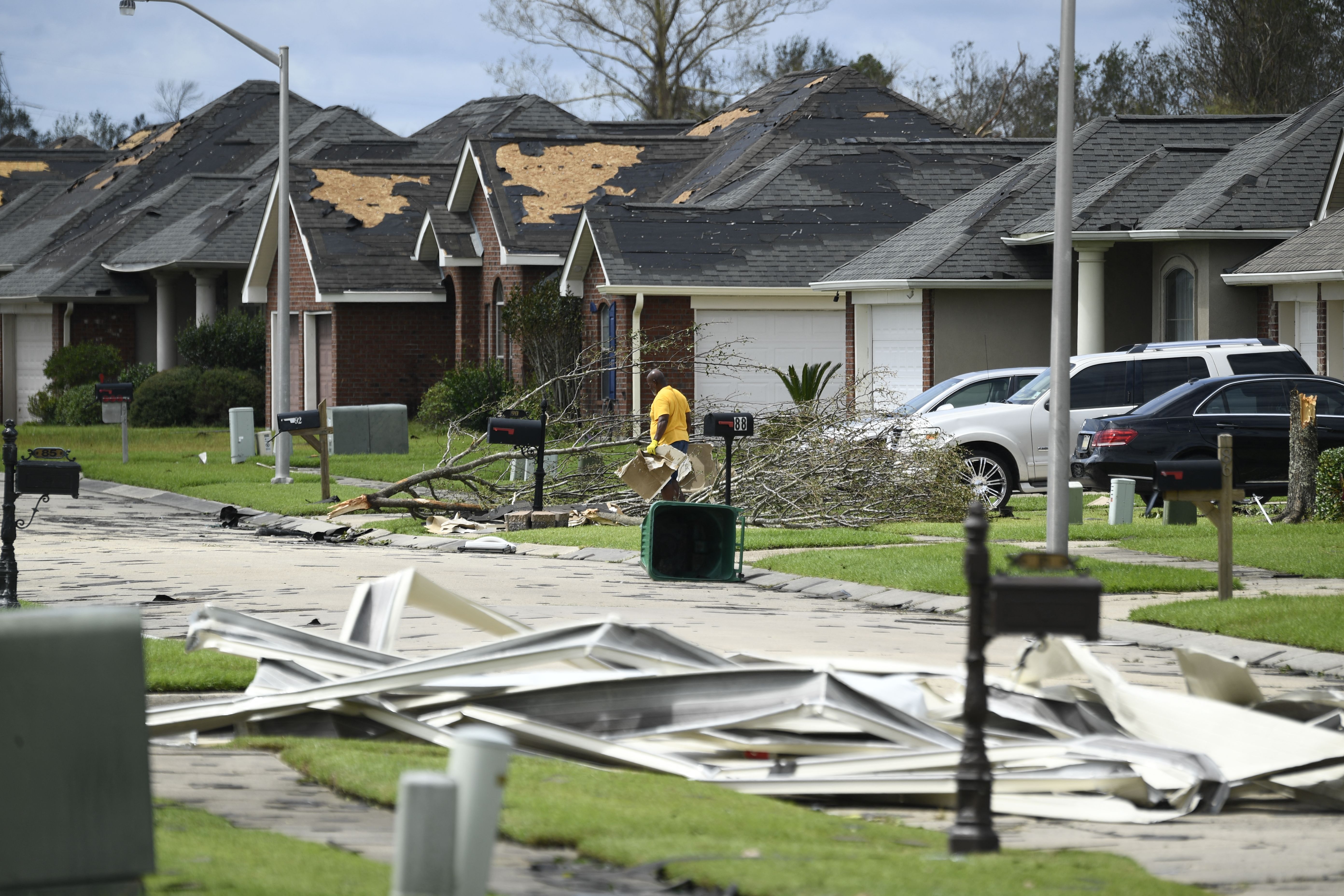 A person picks up debris damage near their home in Laplace, Louisiana, on Aug. 30, 2021, after Hurricane Ida made landfall.