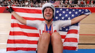 Jennifer Valente of Team United States celebrates winning the gold medal while holding the flag of her country during the Women's Omnium points race, 4 round of 4 of the track cycling on day sixteen of the Tokyo 2020 Olympic Games
