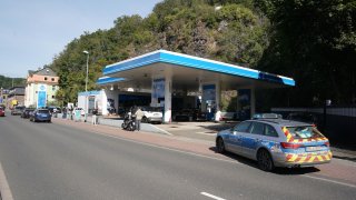 A police car is parked at a gas station in the city center.