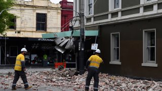 Rescue workers examine a damaged building in the popular shopping Chapel Street in Melbourne on September 22, 2021, after a 5.8-magnitude earthquake.