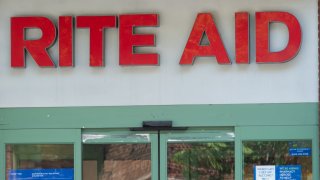 Rite Aid pharmacy sign with person walking in front