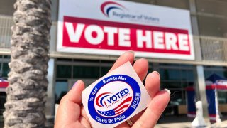 An "I Voted" sticker is held in front of the San Diego Registrar of Voters's office.