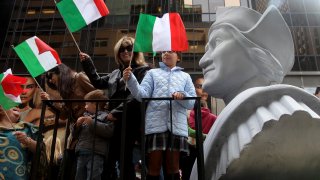 People ride on a float celebrating Columbus Day