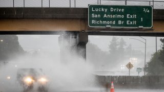 A car drives on Highway 101, which is partially flooded in Corte Madera, Calif.