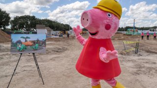 Peppa Pig makes an appearance during a media tour of the Peppa Pig Theme Park construction progress