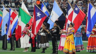 FILE - Flags are displayed during the national anthem in honor of Hispanic Heritage Month before the game between the Dallas Cowboys and New York Giants at AT&T Stadium on Oct. 10, 2021 in Arlington, Texas.