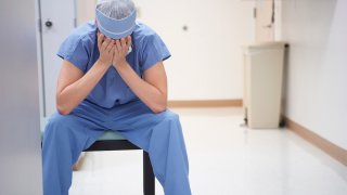 Doctor sitting with head in hands