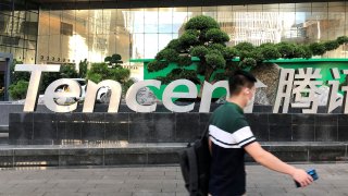 People walk past a Tencent sign at the company headquarters in Shenzhen, Guangdong province, China August 7, 2020.