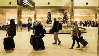 Travelers walk through the Detroit Metropolitan Wayne County Airport on November 21, 2021 in Detroit, Michigan.