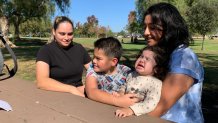 Dos madres con sus hijos en un mesa de un parque