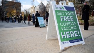People wait in line to get their COVID-19 vaccination at an outdoor walk-up vaccination site within Franklin Park in Washington, DC, on November 29, 2021.