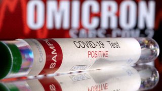 A test tube labelled “COVID-19 Test Positive” is seen in front of displayed words “OMICRON SARS-COV-2” in this illustration taken December 11, 2021.