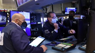 Traders wearing face masks work on the trading floor at the New York Stock Exchange (NYSE) as the Omicron coronavirus variant continues to spread in Manhattan, New York City, U.S., December 20, 2021.