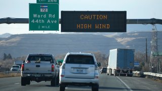 In this photo, an electronic overhead sign warns motorists headed westbound on Interstate 70 at Ward Road as high winds strafed the Denver metropolitan area Wednesday, Dec. 15, 2021, in Arvada, Colo.