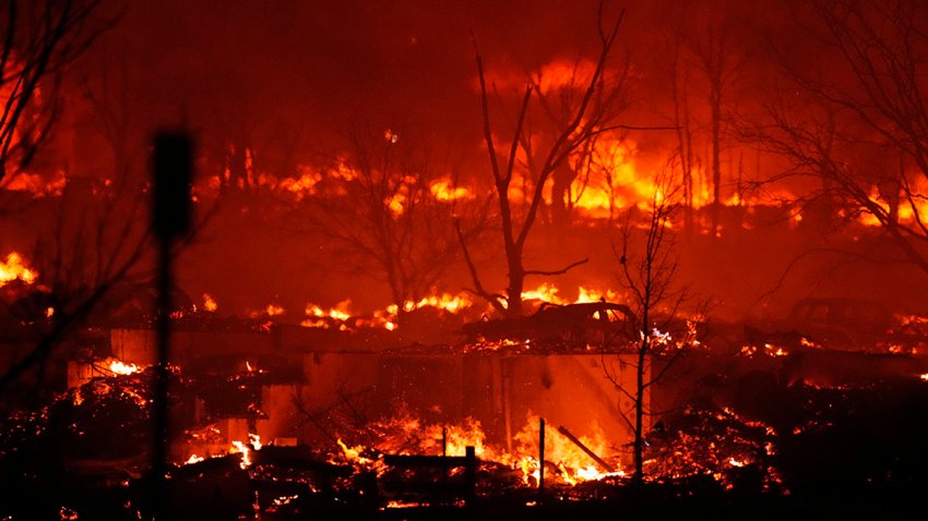 Homes burn as a wildfire rips through a development near Rock Creek Village, Dec. 30, 2021, near Broomfield, Colo.