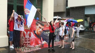 Protestors gather outside an immigration detention hotel where Serbia's Novak Djokovic is believed to stay,