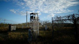 a soldier closes the gate at the now abandoned Camp X-Ray