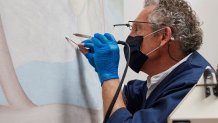 In this photo provided by the Georgia O'Keeffe Museum, Dale Kronkright, head of conservation and preservation at the Georgia O'Keeffe Museum, works on restoring O'Keeffe's painting "Spring," Saturday, Nov. 13, 2021, in Santa Fe, New Mexico.