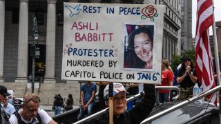 A right wing protester holds a sign about Ashli Babbitt while participating in a political rally on July 25, 2021 in New York City.