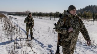 Members of the Ukrainian Border Guard patrol the Ukrainian border fence at the Three Sisters border crossing between, Ukraine, Russia and Belarus on February 14, 2022 in Senkivka, Ukraine.