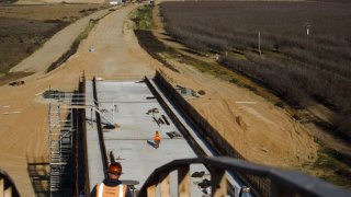 Contractors work during construction on the San Joaquin River viaduct section of a high-speed rail project in Madera, California, U.S., on Thursday, Feb. 13, 2020. The estimated cost of the controversial project has grown to $80.3 billion, an increase from the $79 billion projected last year. Photographer: Patrick Fallon/Bloomberg via Getty Images