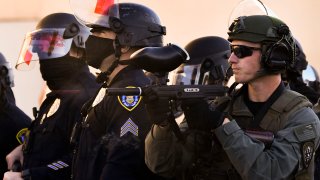 A pepper ball exits the barrel of a San Diego Police Department (SDPD) officer's Tippmann FT-12 paintball gun while firing pepper balls toward counter-protesters as they stand against demonstrators holding a "Patriot March" demonstration in support of US President Donald Trump on January 9, 2021, in the Pacific Beach neighborhood of San Diego.