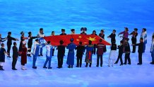 Performers symbolizing the 56 ethnic groups of China carries the national flag during the opening ceremony of the Beijing 2022 Winter Olympic Games in Beijing, Feb. 4, 2022.